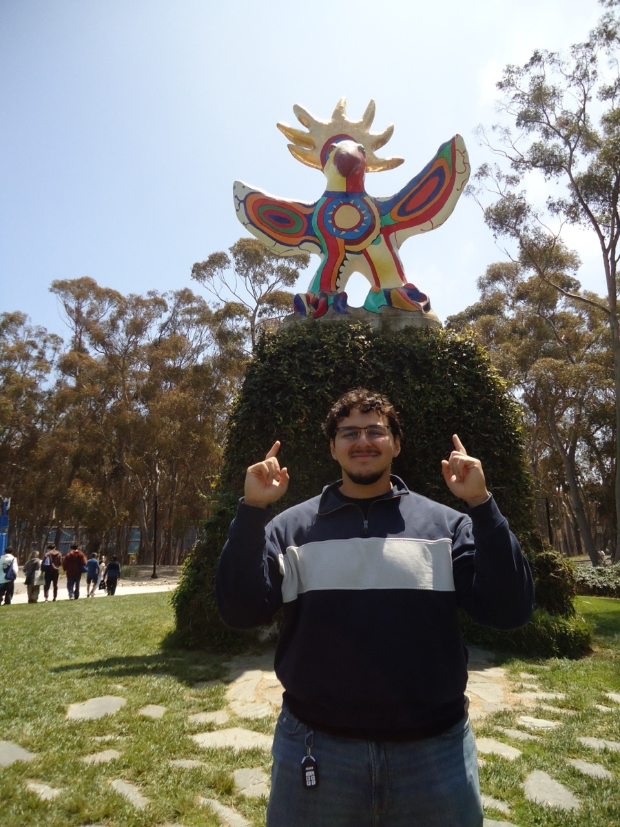 Diego pointing up at the Sun God sculpture at UC San Diego